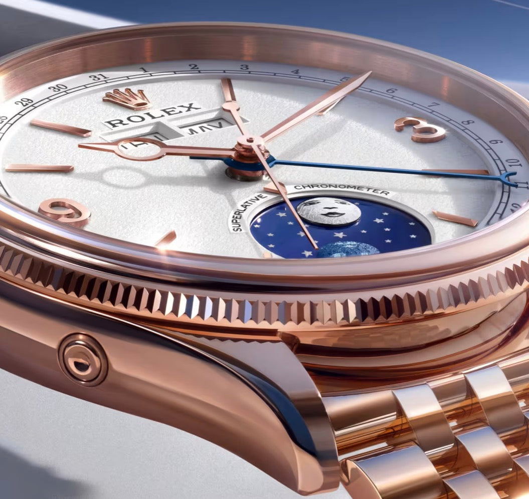 Close-up of a rose-tone Rolex watch with a white calendar dial and blue moonphase display