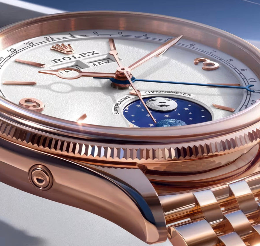 Close-up of a rose-tone Rolex watch with a white calendar dial and blue moonphase display